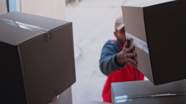 Young man unloading cardboard boxes from the truck — Stock Video