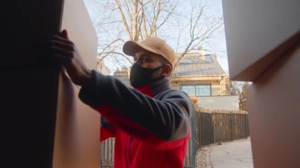 Jeune courrier déchargeant des colis du camion — Video