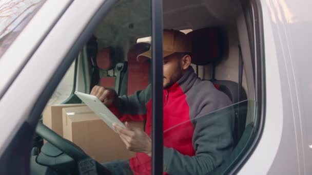 Young indian man courier using tablet while delivering parcel — Stock Video