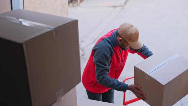 Young man unloading cardboard boxes from the truck — Stock Video