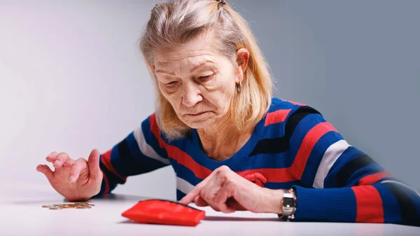 Triste pobre mulher idosa contando moedas e olhando para uma carteira vazia — Fotografia de Stock