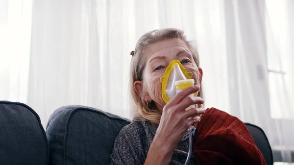Femme plus âgée utilisant un masque respiratoire inhalant des médicaments pour nettoyer sa gorge et ses sinus — Photo