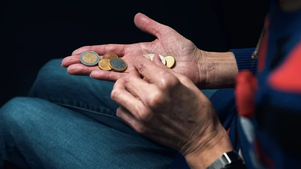 Una anciana contando monedas en sus manos arrugadas. De cerca. — Foto de Stock