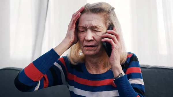 Отчаянная старуха разговаривает по телефону со слезами — стоковое фото