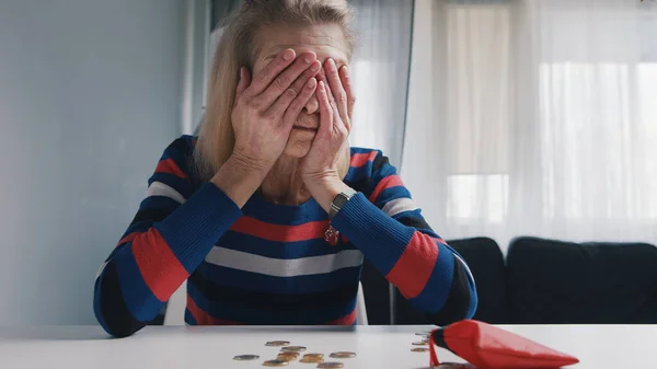 Zavallı yaşlı kadın masada bozuk para sayıyor. Finansal sorunları olan umutsuz yaşlı bir kadın. — Stok fotoğraf