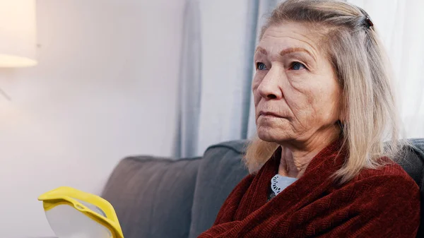 Uma velhota vulnerável a fazer um telefonema e a usar um inalador. Dificuldade em respirar na velhice — Fotografia de Stock
