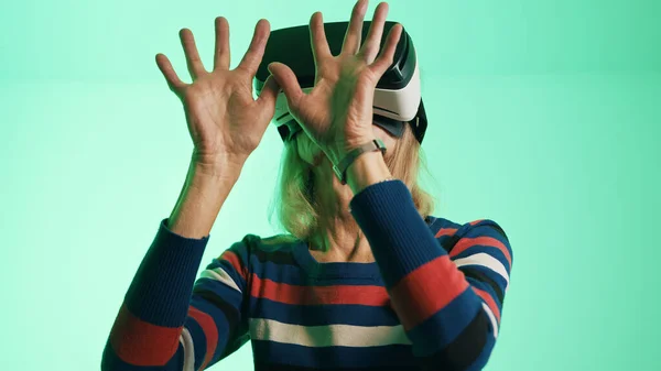 Elderly woman with Virtual Reality glasses touching the air — Stock Photo, Image