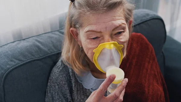 Chora staruszka wdychająca tlen w domu — Zdjęcie stockowe