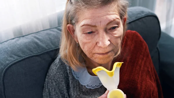 Sick old woman inhaling oxygen at home