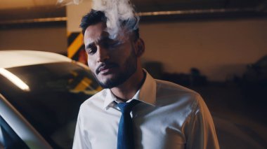 Yetişkin ırkı rahat bir adam sigara dumanı püskürtüyor.