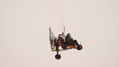 Paramotor trike 'nin yan görüntüsü paraşütle sallanıyor.