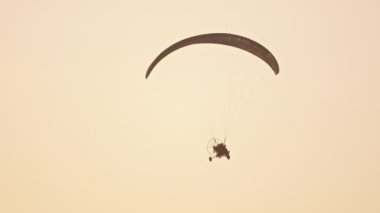 Paramotor silueti havada uçuşuyor.