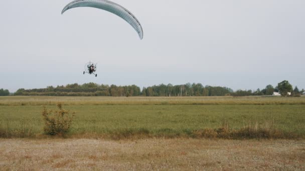 Vôo baixo de trike paramotor acima do aeroporto de grama — Vídeo de Stock