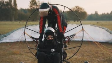 Pilot, Paramotor Trike 'a müşteri ve pervane arasındaki koltukta biniyor.