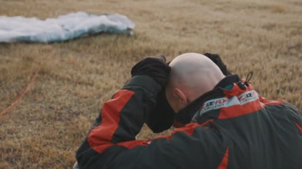 Пилот надевает теплую текстильную балаклаву на голову под защитный шлем — стоковое видео