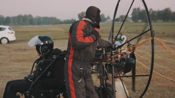 Hombre en mono de vuelo arrancando el motor por cuerda de arranque — Vídeos de Stock