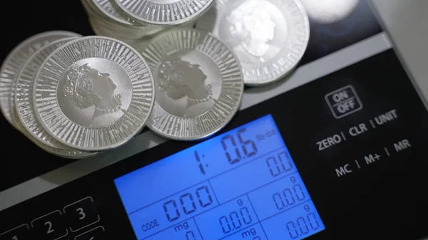 Montón de monedas de plata de inversión que pesan sobre básculas digitales precisas — Foto de Stock