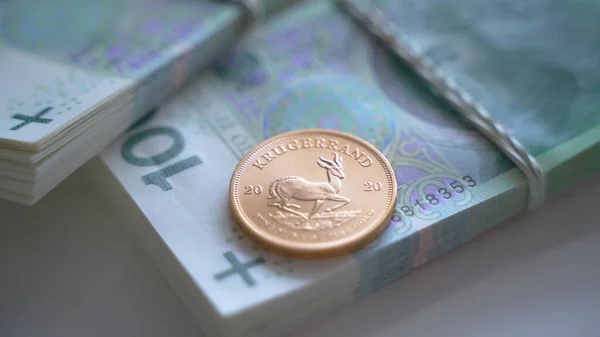 Блискуча інвестиційна монета на пачці з 100 польських банкнот злотих — стокове фото