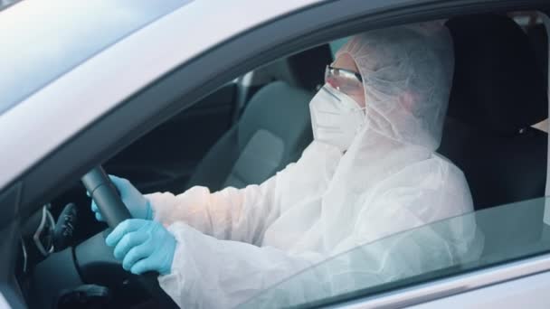 Pessoa não identificável em proteção geral terno carro de condução. Vista da janela lateral do carro no homem na área de risco de infecção. — Vídeo de Stock