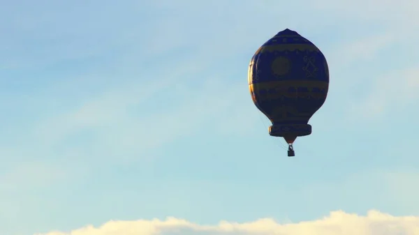 Balão de ar quente colorido contra um belo céu azul nublado - Durante o dia — Fotografia de Stock