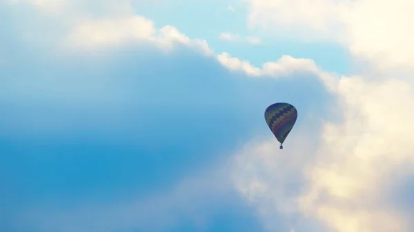 Luchtfoto van kleurrijke heteluchtballon vliegen tegen de schilderachtige bewolkte blauwe lucht — Stockfoto