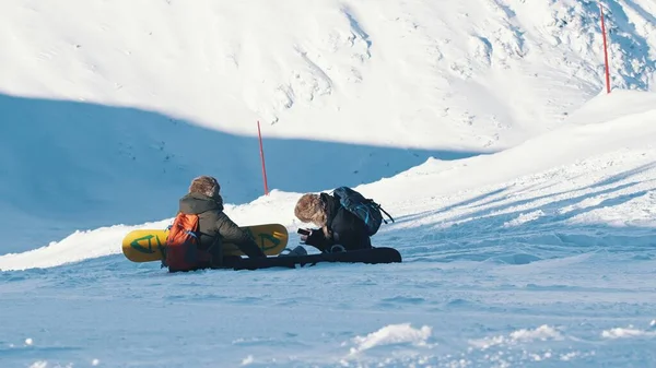 Dwóch narciarzy siedzących na pokrytej śniegiem górze - narciarze robią sobie przerwę — Zdjęcie stockowe