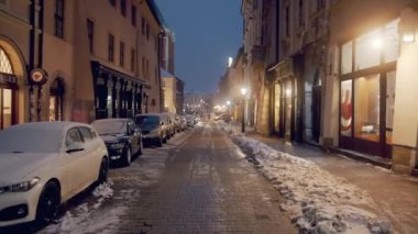 Parked cars covered with snow in Krakow - Light snowfall - Winter season concept