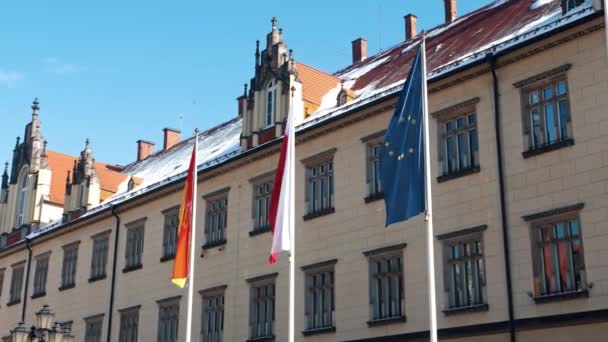 Slow motion footage of facade of building with Polish flags. Market square — Stockvideo