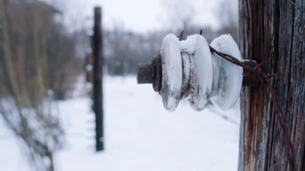 Closeup view of snow-covered electric fence with barbed wires in Auschwitz Birkenau — Stockvideo