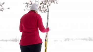 Kırmızı ceketli, kayak yapan genç bir bayan kayakçının yakından görüntüsü.