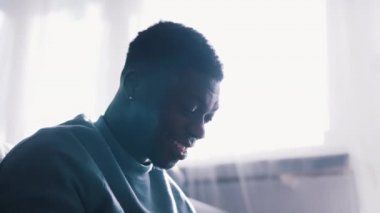  Kanepede oturup video izleyen Afro-Amerikalı bir adam.