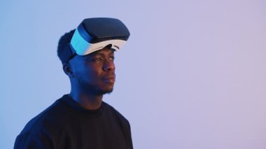 Afro-Amerikalı adam sanal gerçeklik gözlüğü takıyor. 