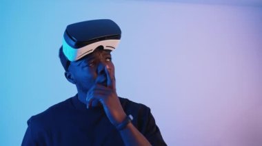 Alnında sanal gerçeklik gözlüğü olan Afro-Amerikalı bir adam.