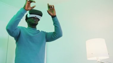 Gözlük takan ve kulaklık takan bir adam 360 derece sanal ortamın keyfini çıkarıyor.
