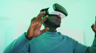 Gözlük takan ve kulaklık takan bir adam 360 derece sanal ortamın keyfini çıkarıyor.