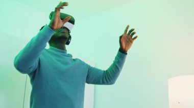 Gözlük takan ve kulaklık takan bir adam 360 derece sanal ortamın keyfini çıkarıyor.