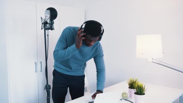 Homme portant des écouteurs debout devant un microphone - Enregistrement d'une chanson — Video