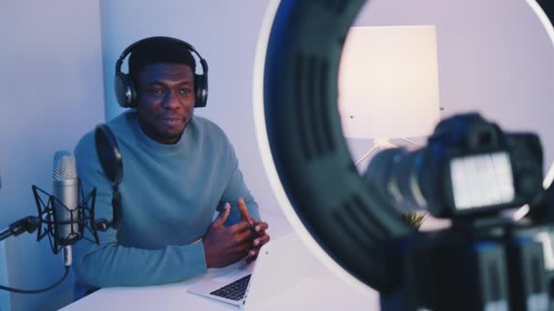 Afrikai-amerikai fülhallgató visel magyarázó valamit - Nézi a kamera — Stock videók