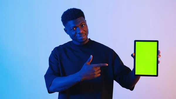 Afro-Amerikalı siyah bir adam elinde tableti gösteren yeşil ekranlı dijital bir tablet tutuyor. — Stok fotoğraf