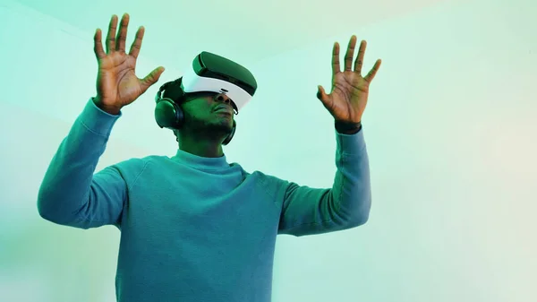 Mężczyzna w okularach VR i słuchawkach korzystających z wirtualnego środowiska 360 stopni — Zdjęcie stockowe