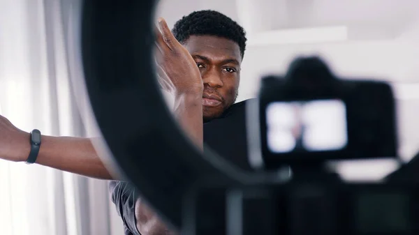 Zwart guy doen arm strekt opwarmen voor een workout voor een camera — Stockfoto