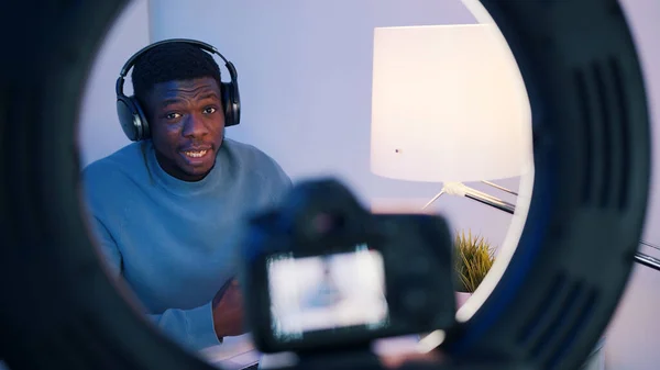 Imagens de perto da tela da câmera mostrando um homem afro-americano usando fones de ouvido sentado na mesa explicando algo. Conceito de aulas online ou podcasts. — Fotografia de Stock