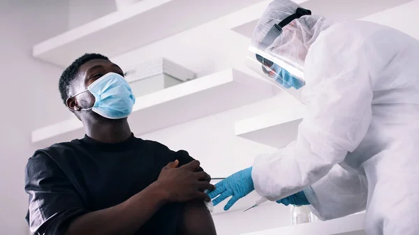 Vacunación e inmunización frente a covida19. africano americano negro hombre recibiendo jab — Foto de Stock