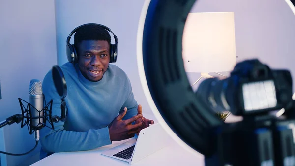 Imagens de perto da tela da câmera mostrando um homem afro-americano usando fones de ouvido sentado na mesa explicando algo. Conceito de aulas online ou podcasts. — Fotografia de Stock