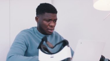 Genç Afrikalı Amerikalı siyahi adam VR gözlük takıyor.