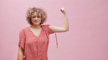 Kıvırcık saçlı güzel kız güç ve güç kavramını gösteriyor.