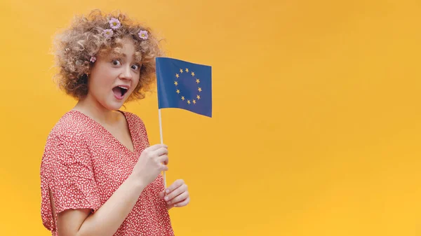 Une fille stupéfaite arborant un petit drapeau de l'Union européenne Symbole de l'association de l'UE — Photo