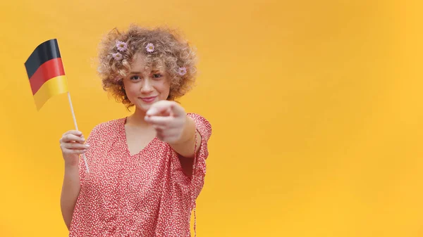 Attraktives junges Mädchen mit einer kleinen deutschen Fahne in der Hand - Studioaufnahme — Stockfoto