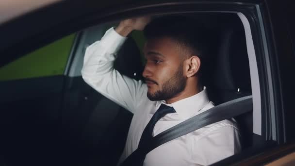 Jeune employé fatigué assis dans le siège de conduite de la voiture portant la ceinture de sécurité — Video