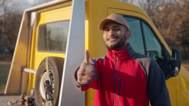 Giovane meccanico indiano indossa un tappo sorridente che fa Pollici fino segno alla fotocamera — Video Stock